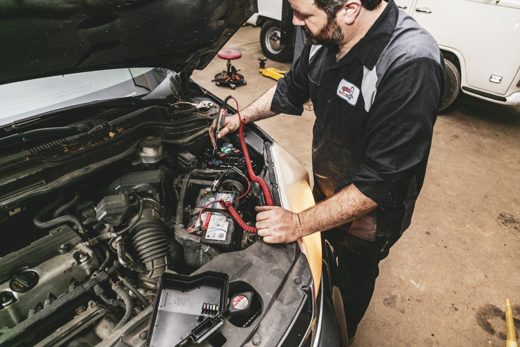 Technician checking a vehicle's battery and charging system