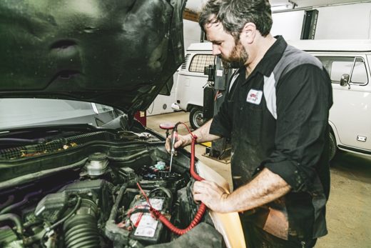 Auto Solve technician tracing an electrical fault under the hood with a test light