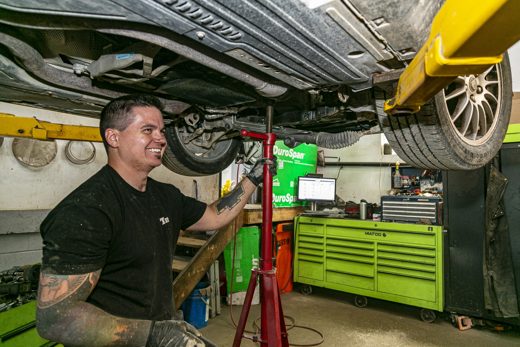 Auto Solve technician under a raised vehicle during the multi-point inspection