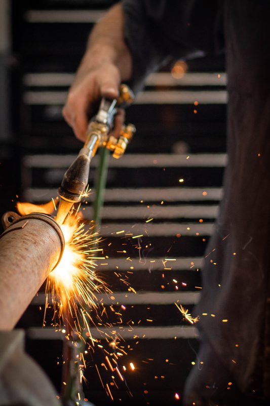 Torch cutting exhaust pipe with sparks