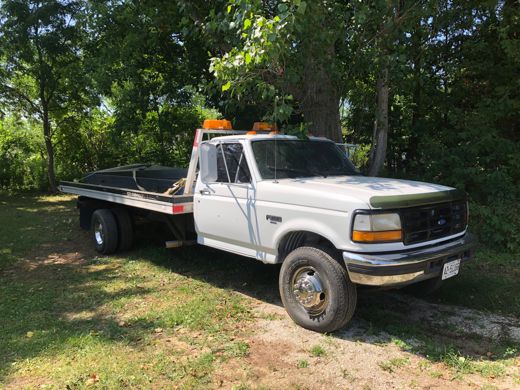 White Ford flatbed tow truck