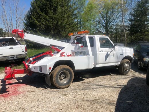 White Auto Solve wrecker with its boom raised