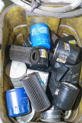 Bin of used oil filters removed during oil changes at Auto Solve